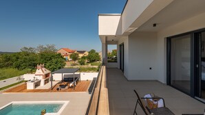 A modern outdoor balcony with a pool, a barbecue area, and a seating area with a table and chairs. - Villa Roma Murvica Zadarvillas (Policnik)