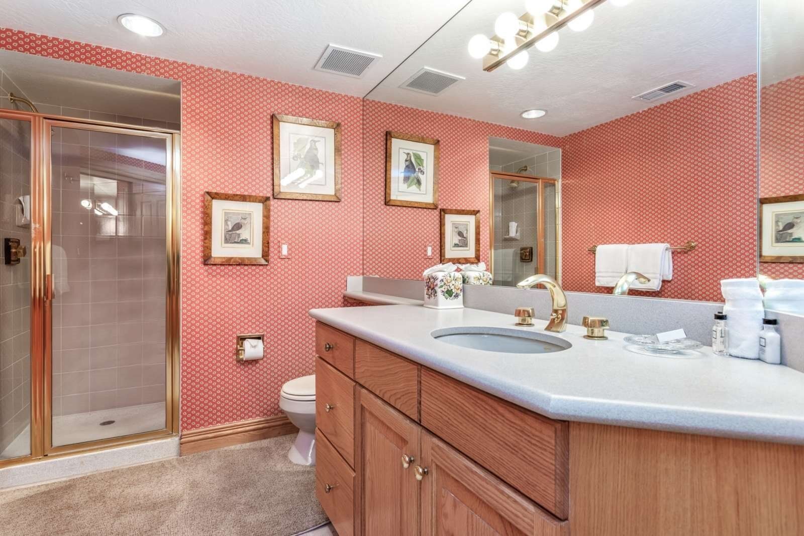 Une salle de bain avec un grand miroir, un lavabo et des toilettes.