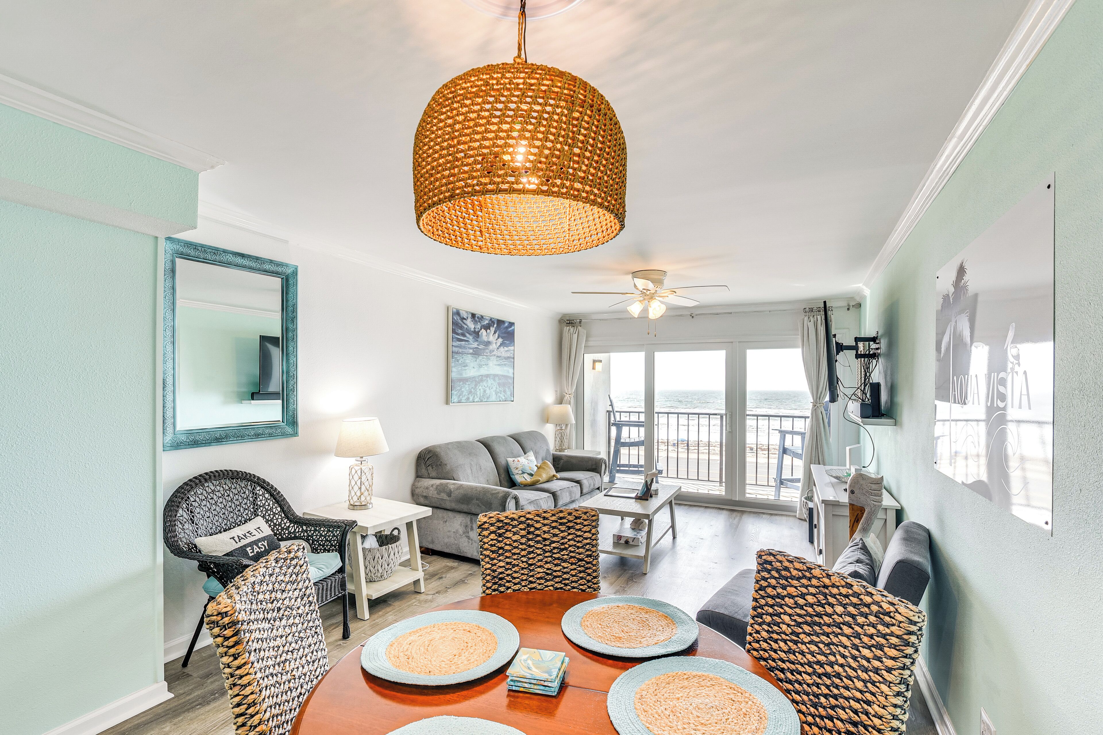 A spacious living area with a dining table, sofas, and a ceiling fan.