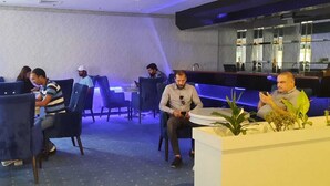 Een moderne zithoek met zitplaatsen en een bar.