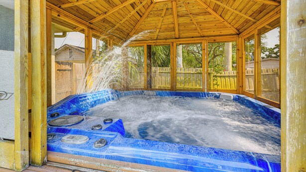 Ein Whirlpool mit Holzdach und Blick auf die Umgebung.