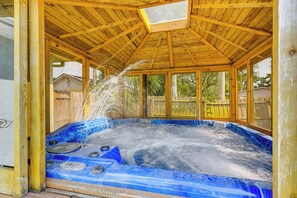 Un jacuzzi con techo de madera y vista del entorno.