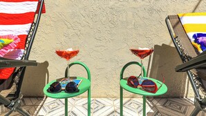 Twee stoelen buiten met parasols, een raam en een structuurwand.
