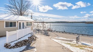 A house with a snow-covered roof and a view of a river.