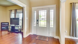 A spacious entryway with hardwood flooring, a white door with glass panels, and a small rug. - 10 Mi to Gulfport Beaches: Family Home w/ Patio (Gulfport)