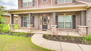 A two-story house with a brick facade, a front porch, and a landscaped front yard. - 10 Mi to Gulfport Beaches: Family Home w/ Patio (Gulfport)