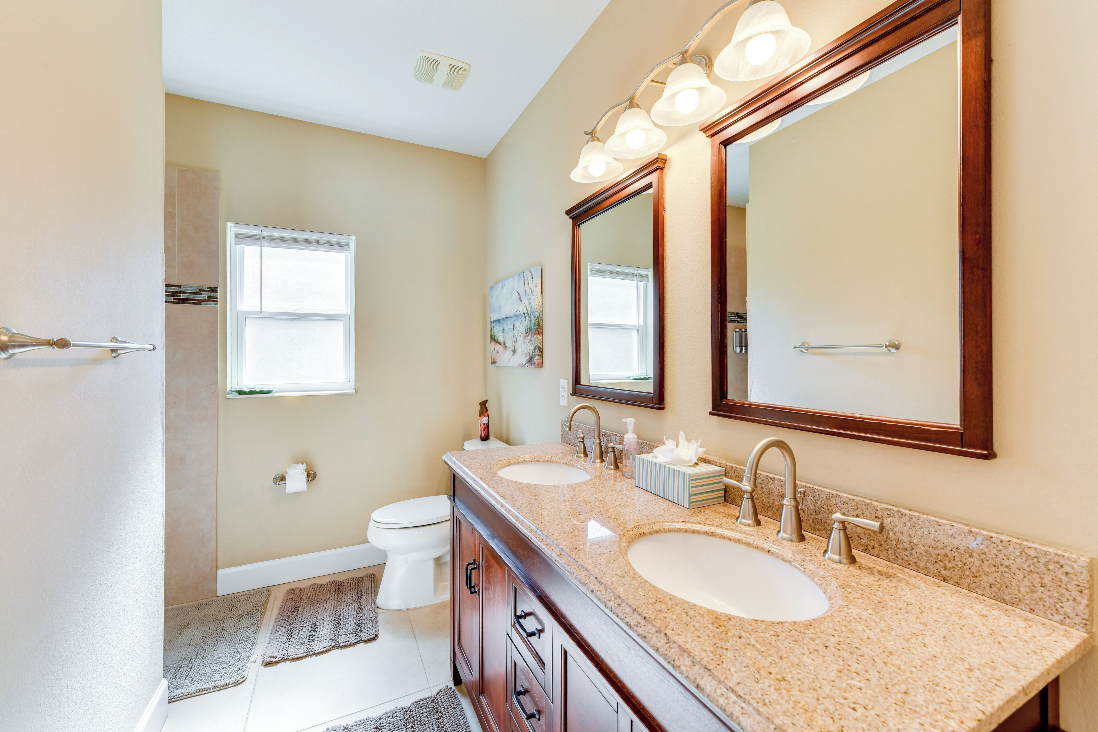 A bathroom with two sinks, a large mirror, and a toilet.