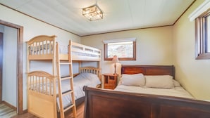 A room with a bunk bed, a single bed, a nightstand, a lamp, and a window. - BBQ Ready: Lakefront Retreat in Watertown (Watertown)