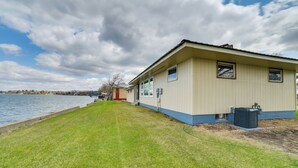 A single-story building with a flat roof, a small porch, and a window with a view of the water. - BBQ Ready: Lakefront Retreat in Watertown (Watertown)
