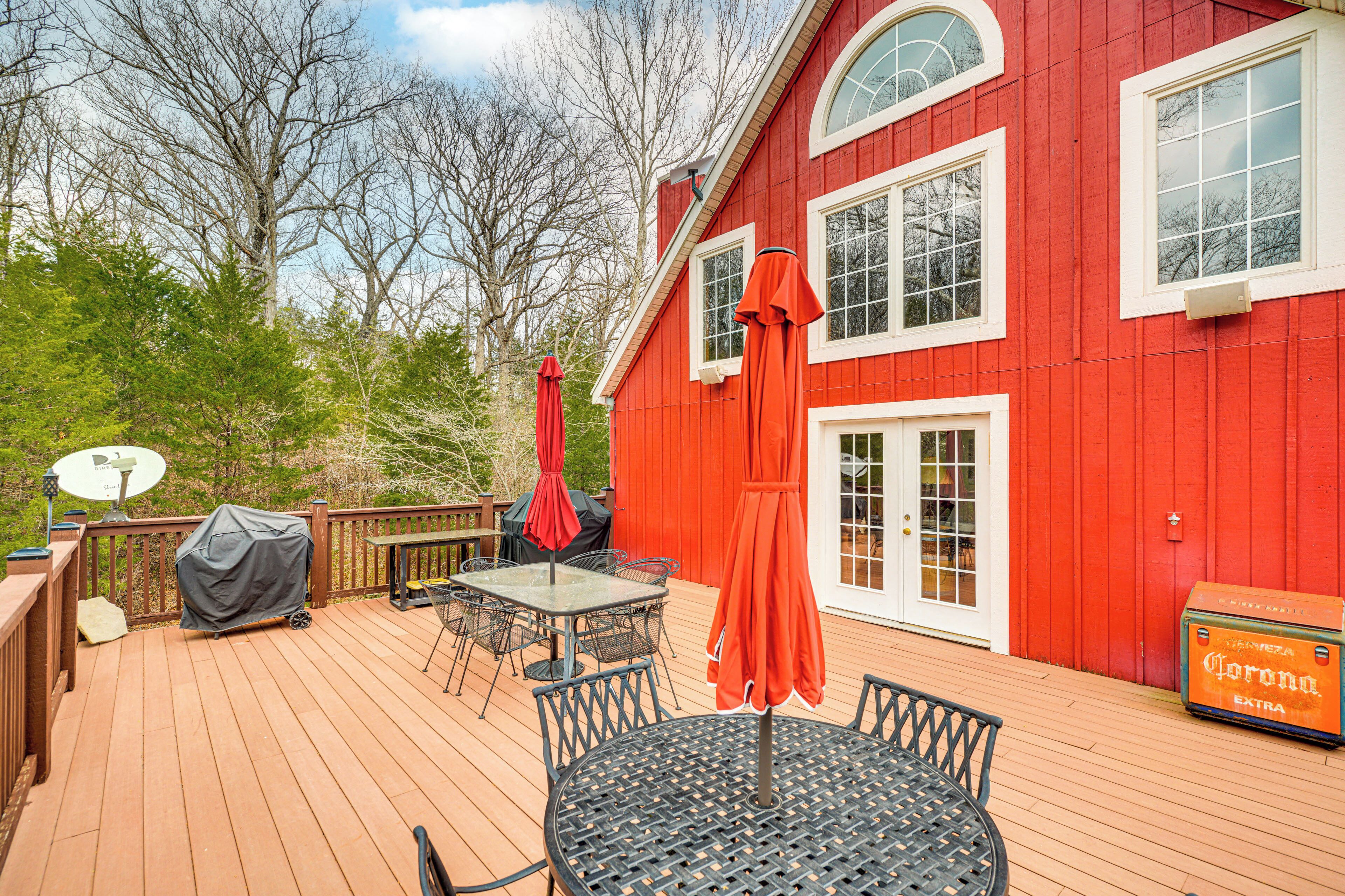 A red house with a deck, outdoor furniture, and a satellite dish.