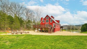 A red barn with a covered porch and a staircase leading to a second floor. - 'the Lodge at Crider Creek' Getaway on 140 Acres! (Bland)