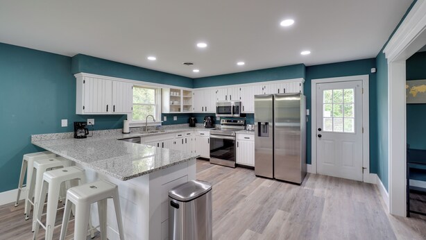 A modern kitchen with white cabinets, stainless steel appliances, and a granite countertop. - Walk to Stores: Home in Historic Shepherdstown! (Shepherdstown)