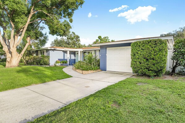 A residential house with a garage, a driveway, and a well-maintained lawn.