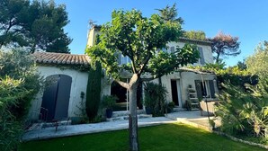 A two-story building with a tiled roof, a central tree, and a well-maintained lawn. - Charming Villa With AC in Alpilles (Paradou)