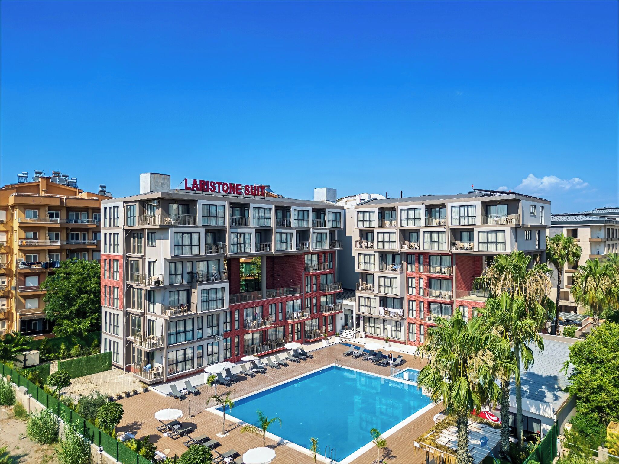 A multi-story hotel with a rooftop pool and outdoor seating area.