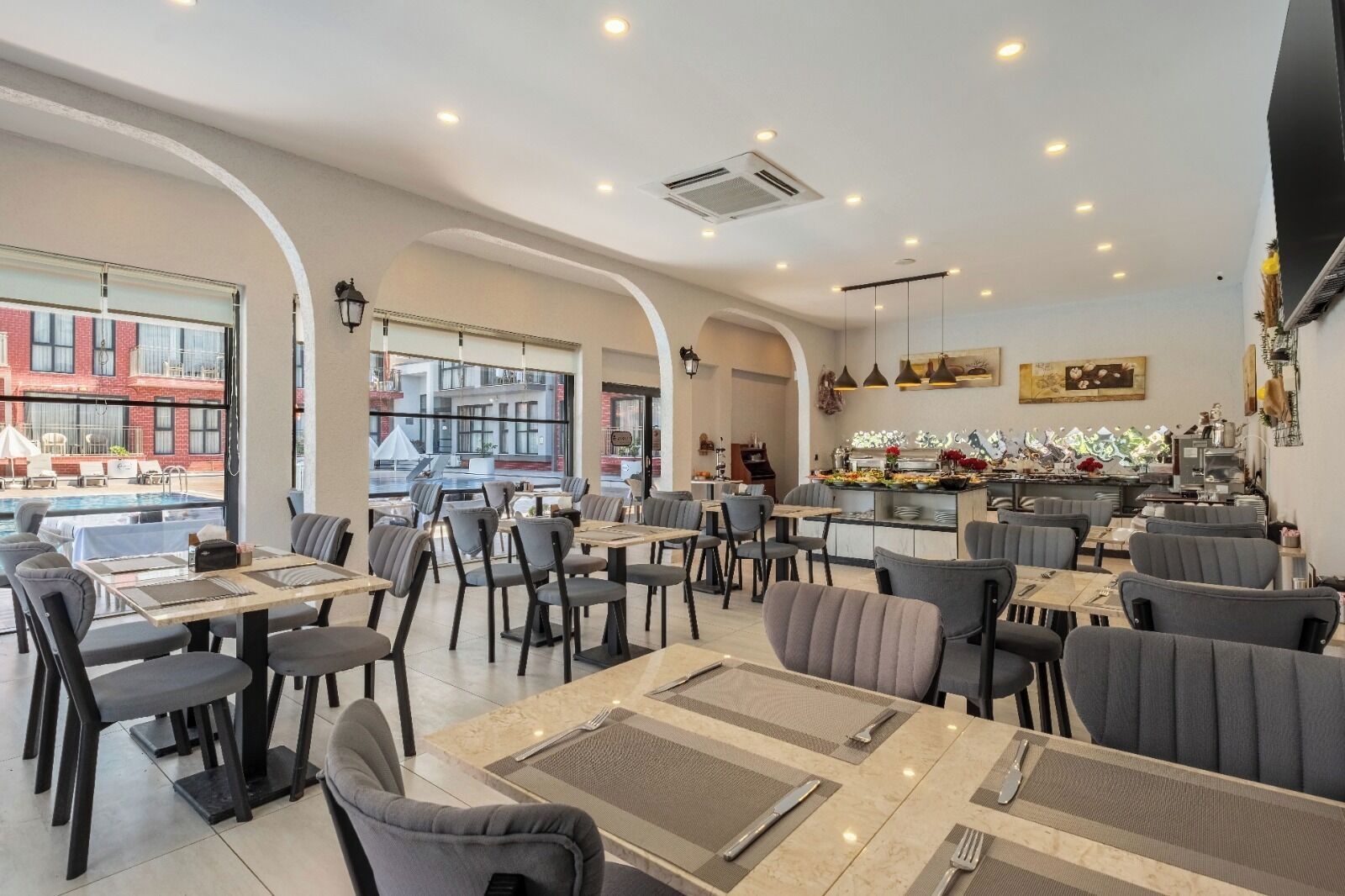 A restaurant with indoor seating, a bar area, and a view of the outside.