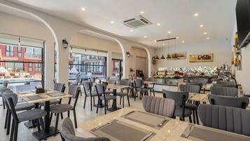 A restaurant with indoor seating, a bar area, and a view of the outside.