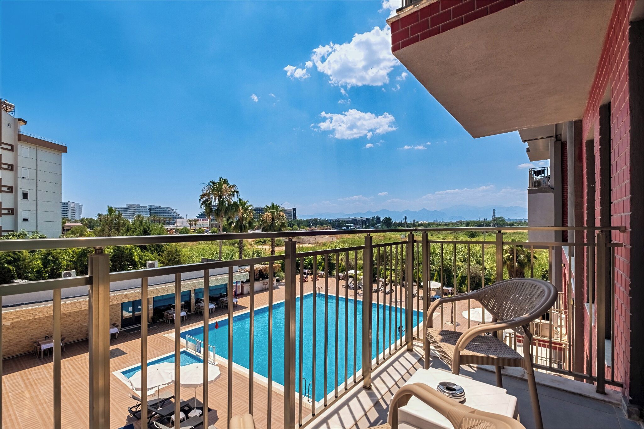A balcony with a pool, outdoor furniture, and a view of the cityscape.