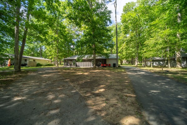 A campground with multiple cabins, a covered picnic area, and a dirt path.