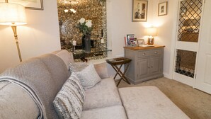 A living room with a sofa, a small side table, a cabinet, and a fireplace. - Shirley's House (Omagh)