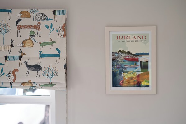 A framed Ireland poster and a patterned curtain.