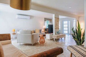 Ein geräumiges Wohnzimmer mit einer Sofagarnitur, einem Couchtisch und einem Fernseher.