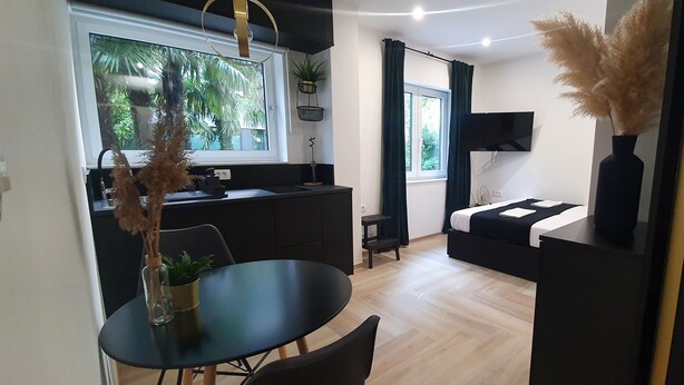 A compact living space with a kitchenette, a dining area, and a bed. - Balance Deluxe Studio Koper (Koper)