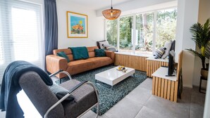A modern living room with a sofa, coffee table, and a TV stand.