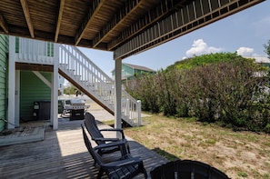 A wooden deck with outdoor seating and a barbecue grill.