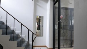Ein modernes Interieur mit Treppe, Glastür und einem Flur.