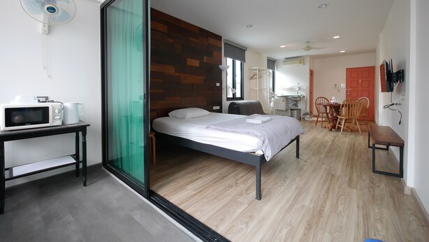 Ein modernes Schlafzimmer mit Bett, Schreibtisch, Stuhl und einem Essbereich mit Tisch und Stühlen.