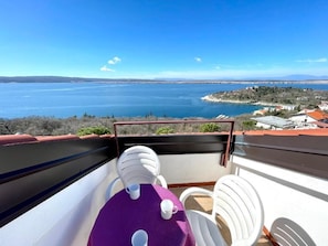 A balcony with a view of a large body of water and a distant shoreline.