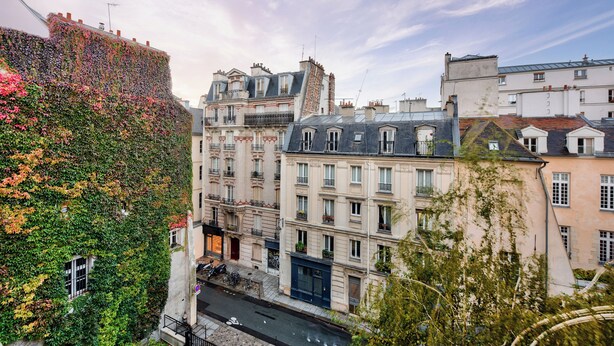 A row of historic buildings with classic European architecture, featuring balconies and a variety of window styles. - Superb T3 near Place des Vosges (Paris)