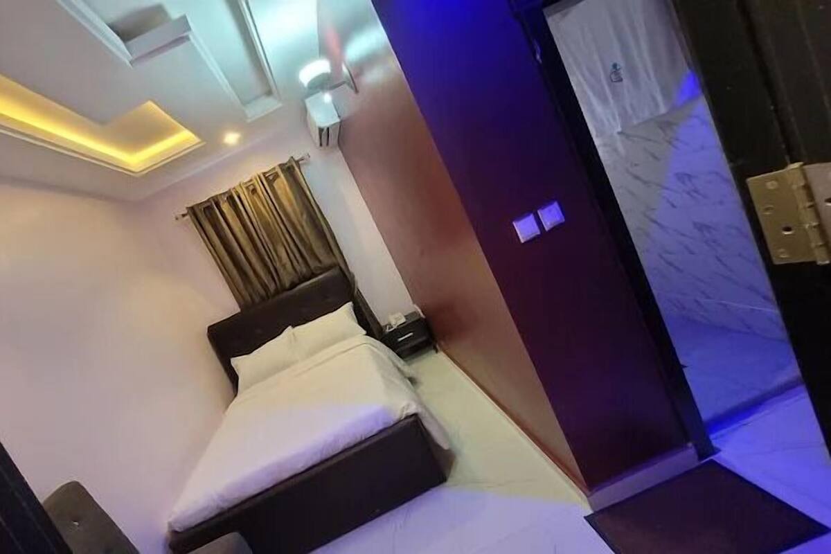 A hotel room with a bed, a desk, and a wardrobe.