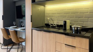 Eine moderne Küche mit schwarzem Arbeitsplatz, Edelstahlgeräten und einem Holzkorpus.