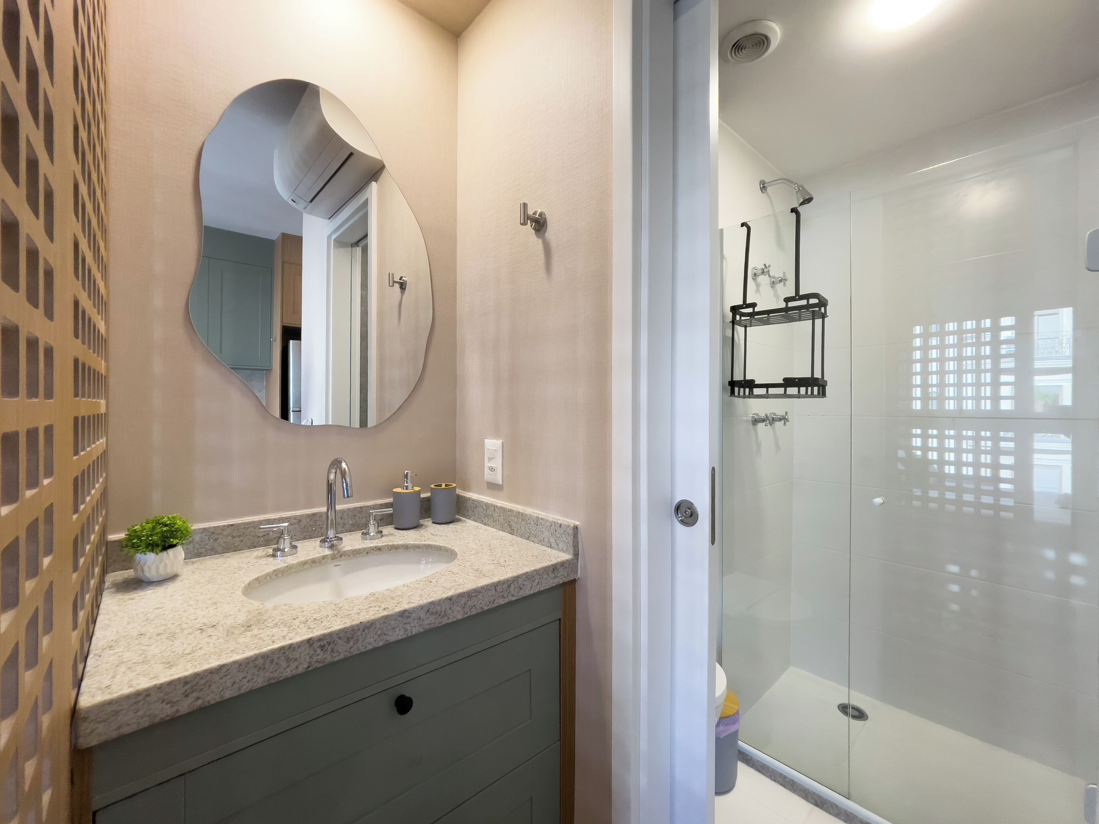 A modern bathroom with a double sink vanity, a large mirror, and a glass-enclosed shower.