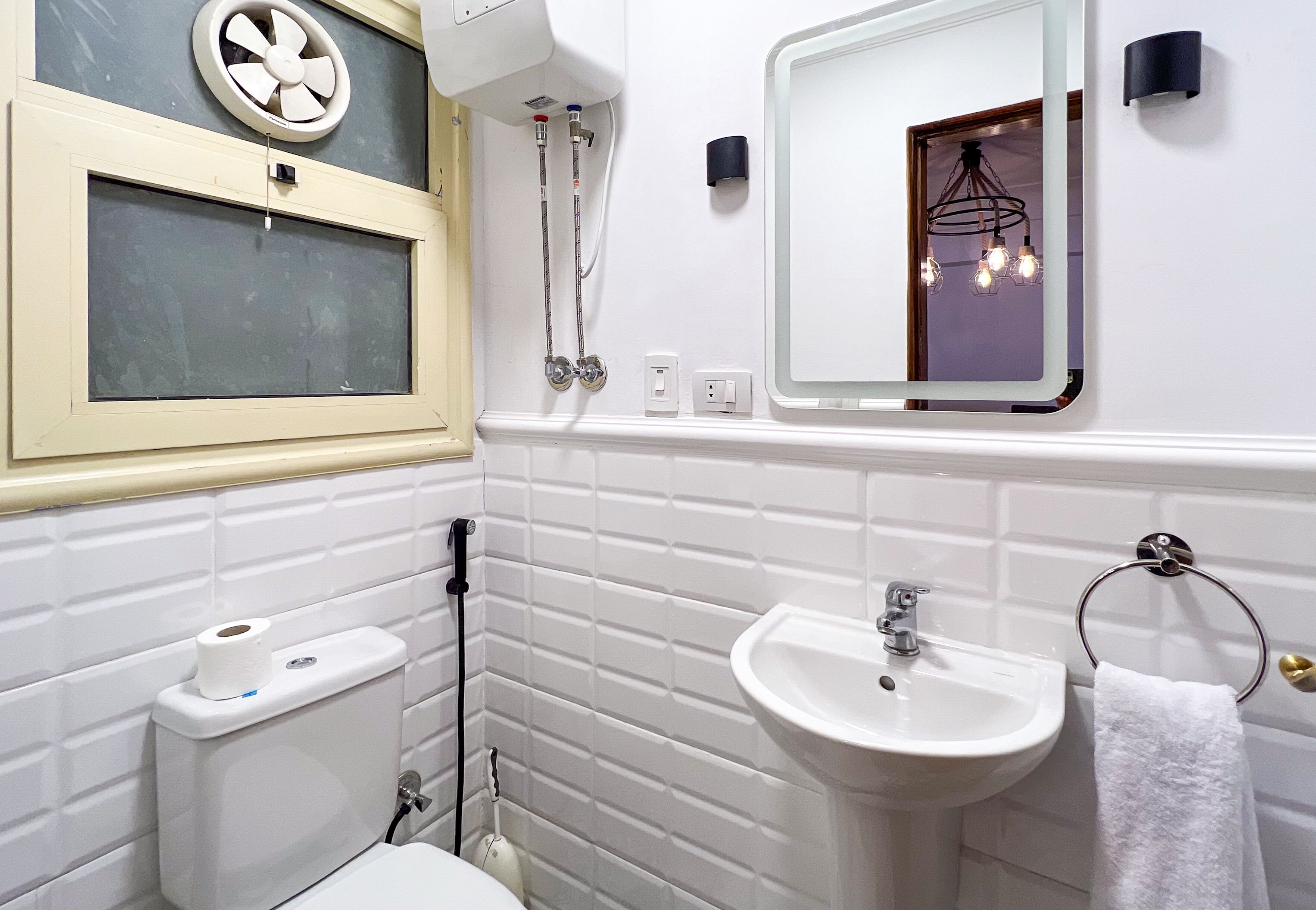 Un baño con inodoro, bidé, lavabo y espejo.