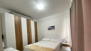 Et hotelværelse med en seng, et natbord, et skrivebord og et klædeskab.