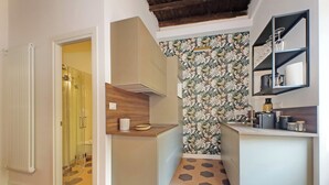 A modern kitchen with a wooden countertop, a built-in oven, and a patterned backsplash. - Cistern Elegant Comfort 2bdr (Roma)