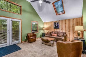 A living room with a ceiling fan, a sofa, a coffee table, and a fireplace. - Count Your Blessings 3 Bedroom Home (Pigeon Forge)