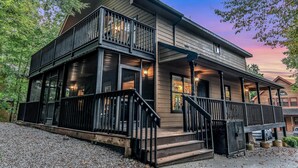 A two-story house with a balcony, large windows, and a porch with steps. - Count Your Blessings 3 Bedroom Home (Pigeon Forge)