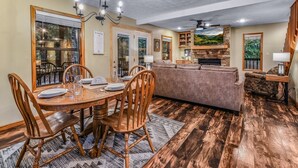 A dining area with a wooden table and chairs, a sofa, and a fireplace. - Count Your Blessings 3 Bedroom Home (Pigeon Forge)