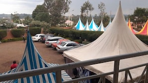 A view of a parking area with tents and cars. - The Guardian Hotel Nyamira (Nyamira)
