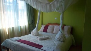 A bed with a canopy, pillows, and a blanket. - The Guardian Hotel Nyamira (Nyamira)