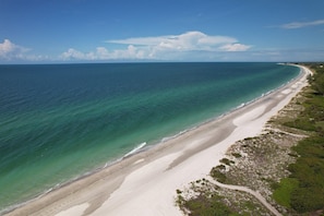 Ett kustlandskap med en sandstrand och fri utsikt över havet.