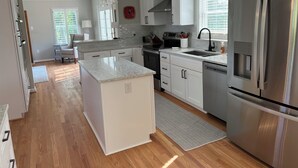 A modern kitchen with white cabinets, stainless steel appliances, and a large island. - Charming 4-bedroom House on beautiful farm in Clear Brook with lovely views (Clear Brook)