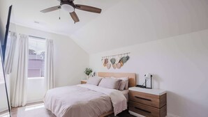 A bedroom with a bed, nightstand, and a ceiling fan. - Walk2OldTown!  Modern Lux Private Carriage House (Bluffton)