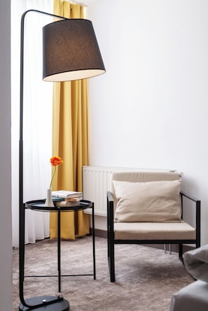 Relax in a cozy seating area with a comfortable armchair and enjoy the warmth of a radiator.
