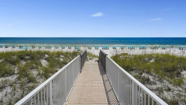 A wooden boardwalk leading to a beach with rows of blue beach chairs and a clear blue sky. - Rue Caribe* Fire pit, special Fall Rates, community pool * Salt Water Vacations (Miramar Beach)