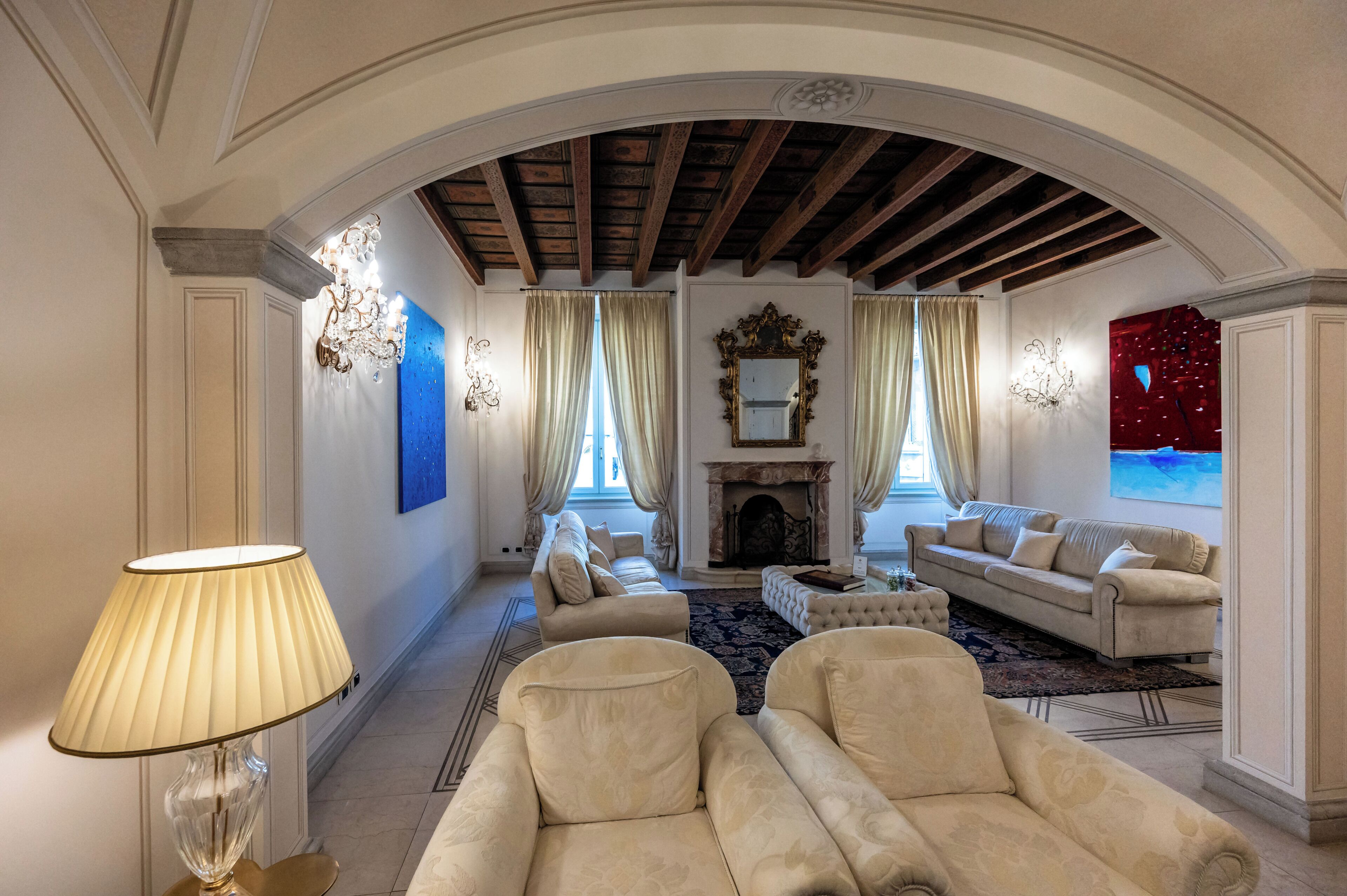A spacious living room with a fireplace, two sofas, and a large rug.